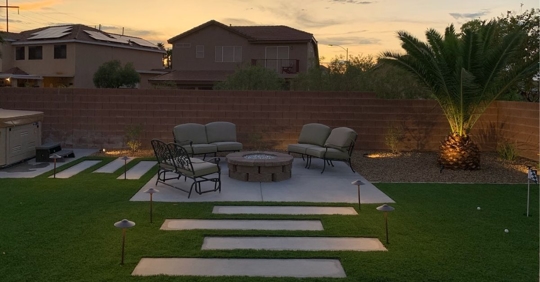 Steps on grass leading up to outdoor seating area.